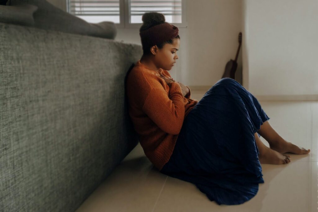 Lady sitting on floor holding her chest